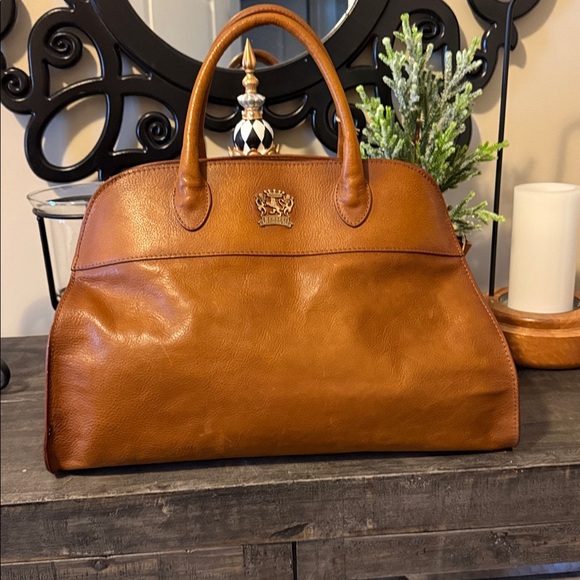 PRATESI tote. I love mine.Fits it all.Expands leave side unbuckled.Love the look